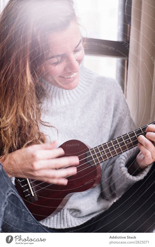 Cheerful woman playing ukulele Woman Home Relaxation Ukulele Playing Lifestyle Musician Smiling Beautiful Room Human being Easygoing Adults