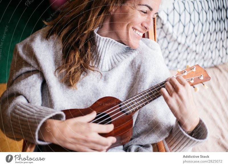 Cheerful woman playing ukulele Woman Home Relaxation Ukulele Playing Lifestyle Musician Smiling Beautiful Room Human being Easygoing Adults