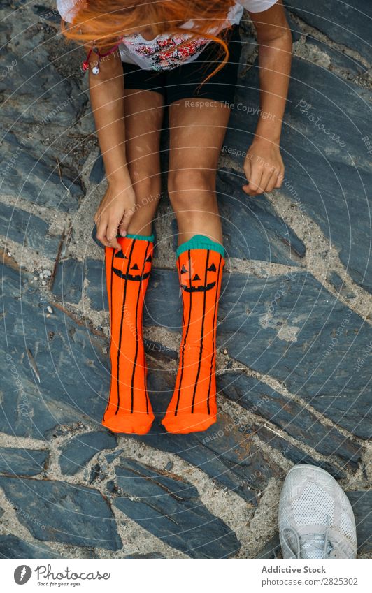 Crop girl putting on creative socks Girl Sock Wear Pumpkin Hallowe'en Autumn Child Clothing Uniqueness Vacation & Travel Fashion Multicoloured Stone Joy