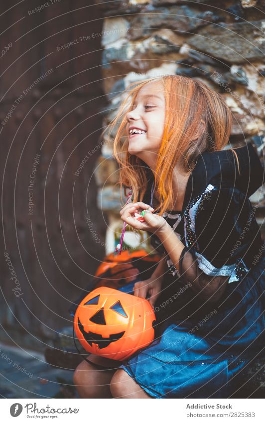 Little girl in witch costume sitting on bench Girl Hallowe'en Candy Bench Dog food Vacation & Travel Entertainment Festival Seasons Costume Tradition Sweet