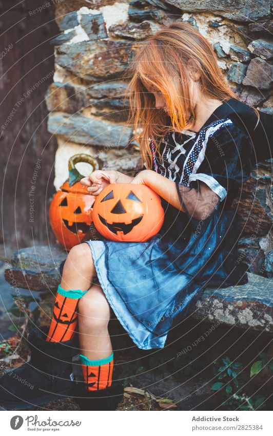 Little girl in witch costume sitting on bench Girl Hallowe'en Candy Bench Dog food Vacation & Travel Entertainment Festival Seasons Costume Tradition Sweet