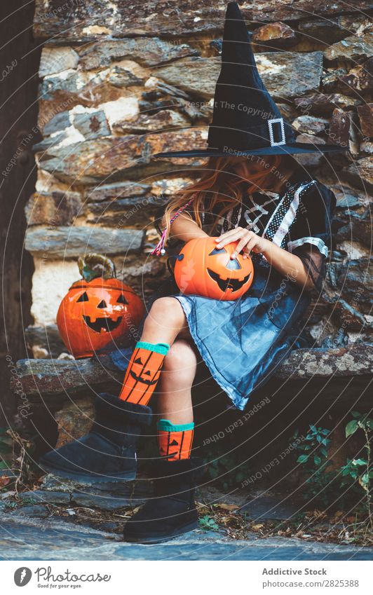 Little girl in witch costume sitting on bench Girl Hallowe'en Candy Bench Dog food Vacation & Travel Entertainment Festival Seasons Costume Tradition Sweet