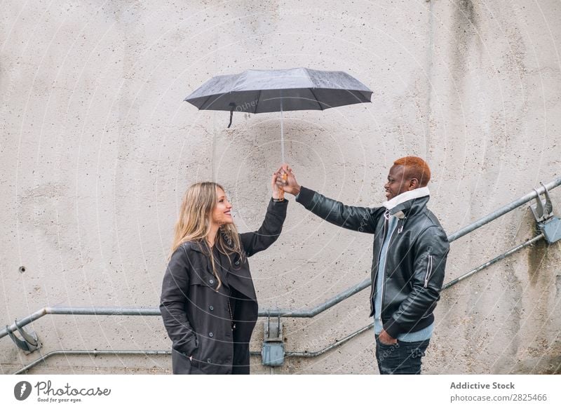 Friends who play in the street with rain. Interracial relationsh diverse Romance 20s pretty American loveliness Relationship Face Body Youth (Young adults)