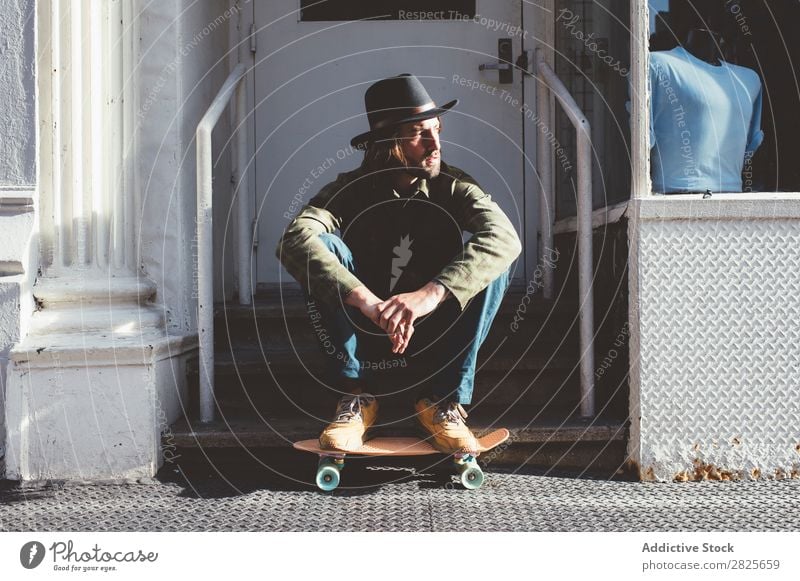 Cool man sitting at stairs Cool (slang) Man Skateboard Sit Stairs Self-confident Hat bearded Earnest Street Brutal Beard Human being City Hipster Adults