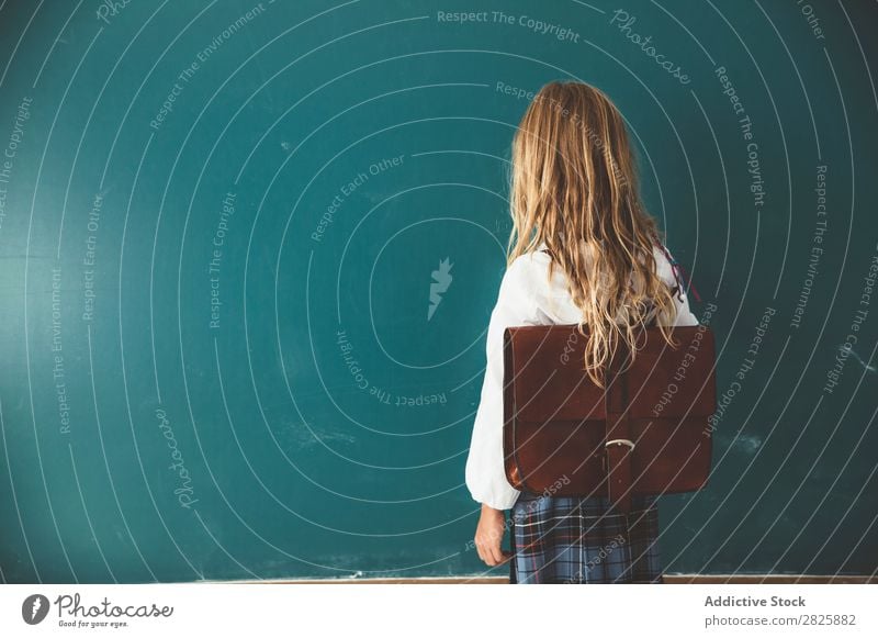 Pupil posing in classroom Girl Classroom Blackboard Stand Cheerful Happy Book Chalk Cute Education School Grade (school level) Student Youth (Young adults)