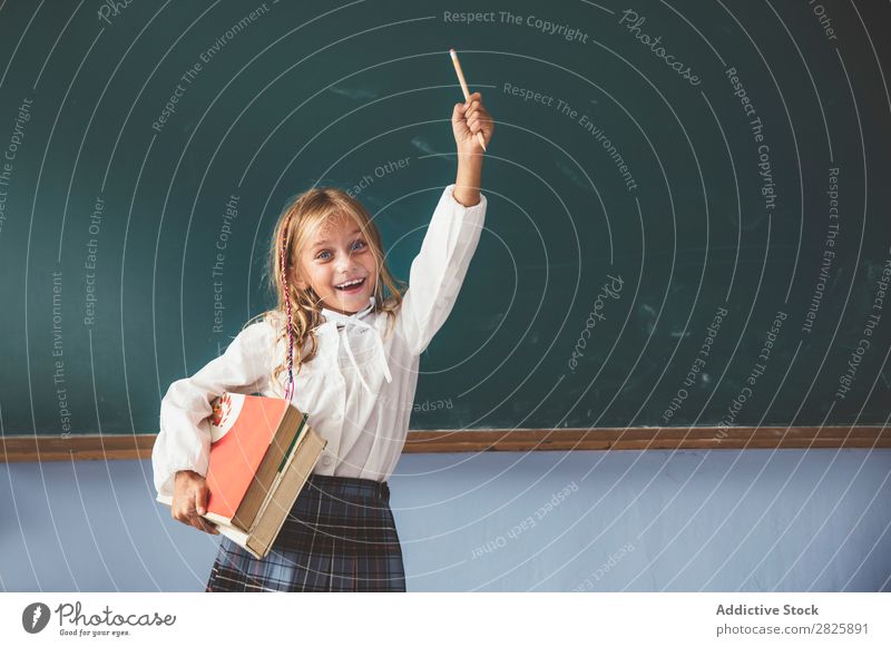 Pupil at chalkboard with hand up Girl Classroom Blackboard Stand Cheerful Happy Smiling Book Chalk Cute Education School Grade (school level) Student