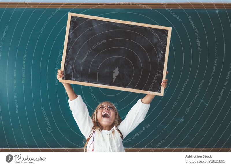 Happy girl standing with chalkboard Girl Classroom Blackboard Stand Hold Scream over head Cheerful Cute Education School Grade (school level) Student