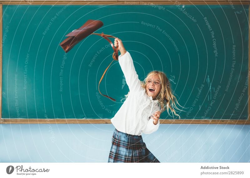 Girl throwing backpack in classroom Classroom Blackboard Joy Backpack Vacation & Travel Happy Cheerful Stand Cute Education School Grade (school level) Student