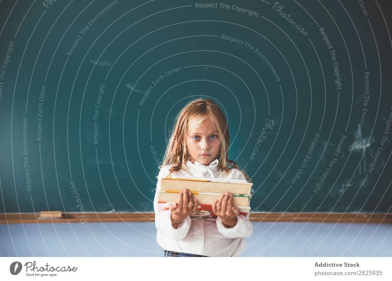 Pupil at chalkboard with books in hand Girl Classroom Blackboard Stand Cheerful Happy Book Chalk Cute Education School Grade (school level) Student