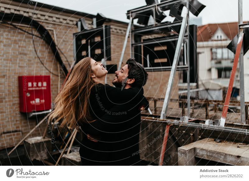 Couple hugging each other on the rooftop Embrace Cheerful City Signage Love Sit Skyline Architecture love story Town Joy Together Happy Youth (Young adults) 2