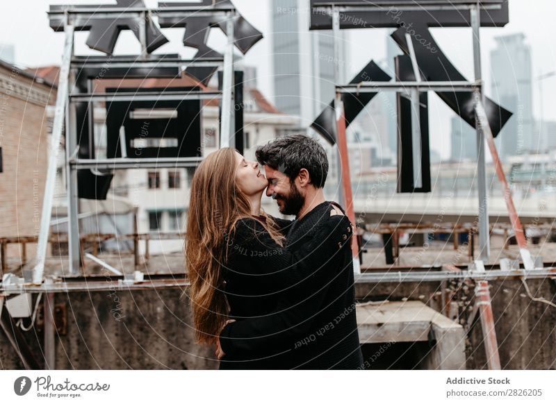 Couple hugging each other on rooftop. Girl kissing guys forehead Embrace City Love Vantage point Kissing Happy romantic Together Beautiful Youth (Young adults)