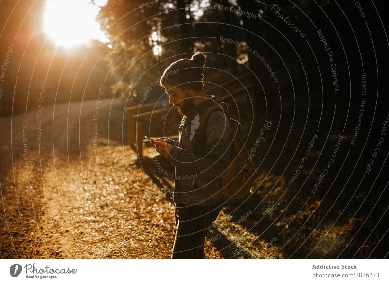 Man usinig a mobile phone in the forest Tourist Forest Portrait photograph texting Backpack Telephone Street Technology Autumn Tourism Vacation & Travel