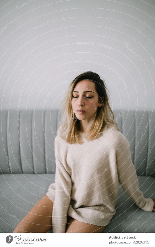 Sleepy female at the couch woman sleepy eyes closed sofa sitting portrait comfortable young home pensive thoughtful attractive beautiful room resting casual