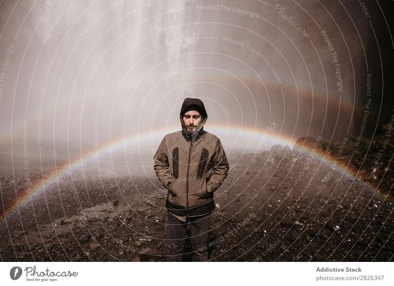 Man posing on background of waterfall Waterfall Rainbow Iceland Stream Fog Tourism Mountain Natural Vacation & Travel Landscape Environment Powerful Flow Energy