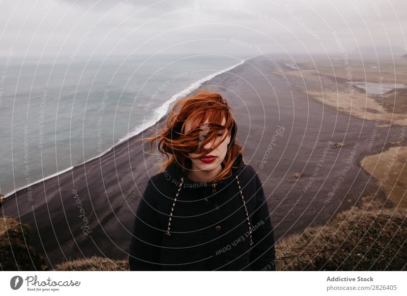 Woman with waving hair on ocean Ocean Iceland Height Landscape Vantage point Rock scenery Extreme Adventure Boundary Top Nature Stand Mountain Wilderness