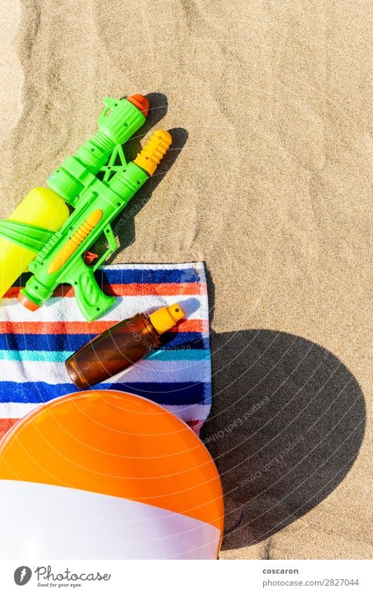 Towel, beach ball, sunscreen and water gun on the beach Bottle Joy Cosmetics Cream Healthy Health care Relaxation Leisure and hobbies Playing Children's game