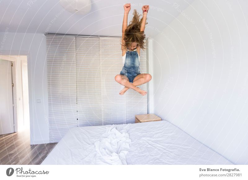 beautiful kid girl playing and jumping on bed Lifestyle Joy Happy Beautiful Leisure and hobbies Playing Reading Summer Bedroom Child Human being Feminine