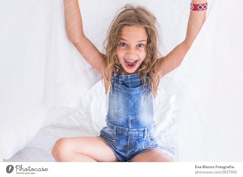 beautiful kid girl playing under white sheets on bed Lifestyle Joy Happy Beautiful Leisure and hobbies Playing Reading Summer Bedroom Child Human being Feminine