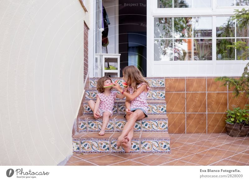 Two beautiful sister kids eating watermelon at home Fruit Ice cream Eating Joy Happy Vacation & Travel Summer House (Residential Structure) Garden Child