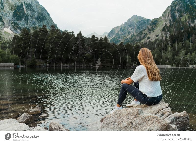 Woman sitting on stone at lake Stone Lake Mountain Nature Landscape Water Rock Beautiful Youth (Young adults) Hiking Vacation & Travel Adventure Trip trekking