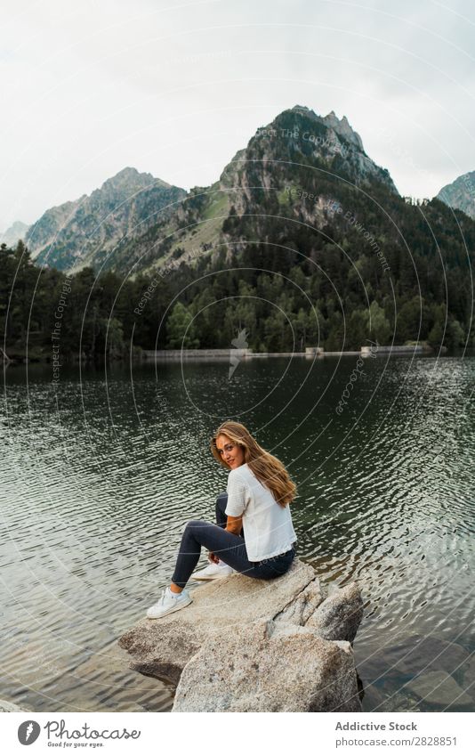 Woman sitting on stone at lake Stone Lake Mountain Nature Landscape Water Rock Beautiful Youth (Young adults) Hiking Vacation & Travel Adventure Trip trekking