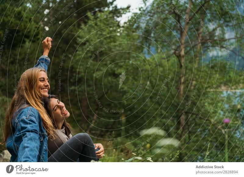 Cheerful women sitting at lake Woman Mountain Smiling Sit Together Happy Laughter Hiking Lake Water embracing Vacation & Travel Adventure Tourist