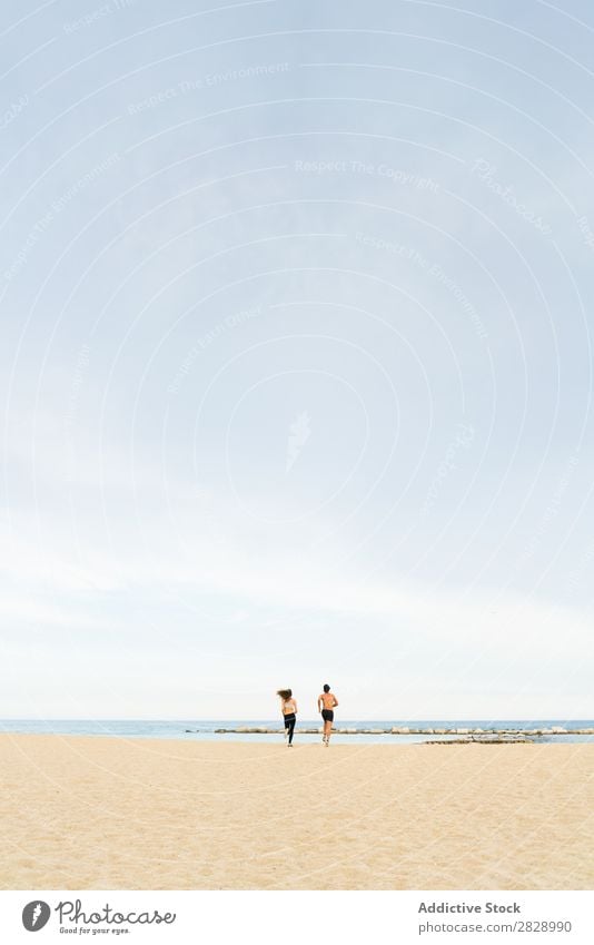 Young sportive couple on beach Couple Athletic Beach Town Coast Teamwork Embrace Fitness Landscape City Support shirtless Sportswear embracing Happiness