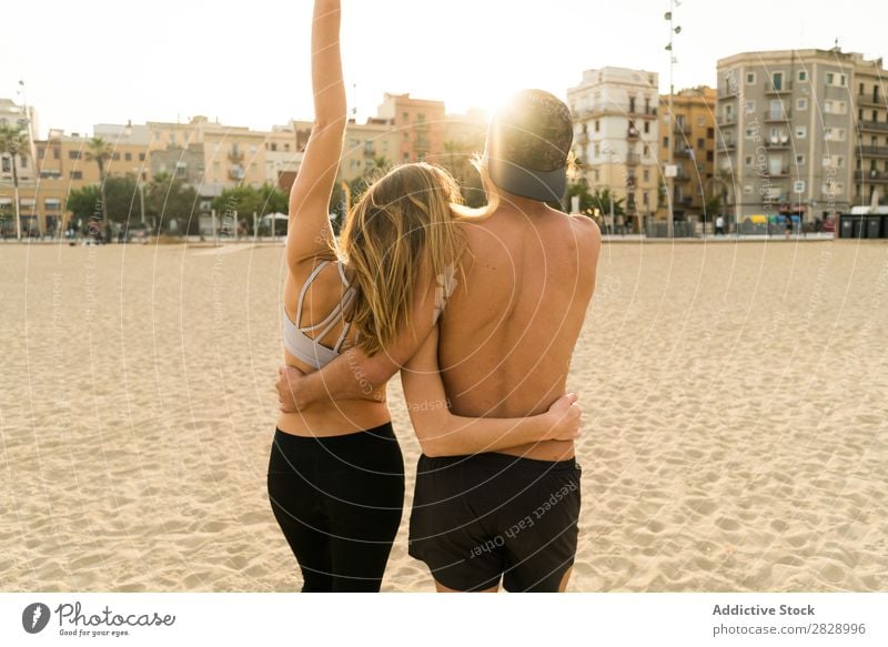 Back view of sportive couple Couple Beach achievement Teamwork Success Athletic Town Gesture Embrace Coast Fitness Landscape City Support shirtless Sportswear