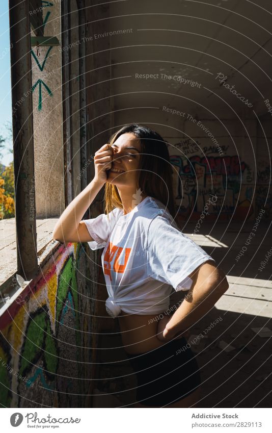 Smiling woman in abandoned room with graffiti Woman Cheerful Posture Looking into the camera Happy Youth (Young adults) grungy Graffiti Multicoloured Room