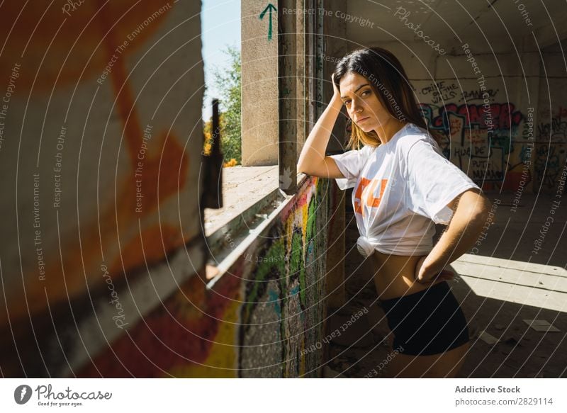 Smiling woman in abandoned room with graffiti Woman Cheerful Posture Looking into the camera Happy Youth (Young adults) grungy Graffiti Multicoloured Room