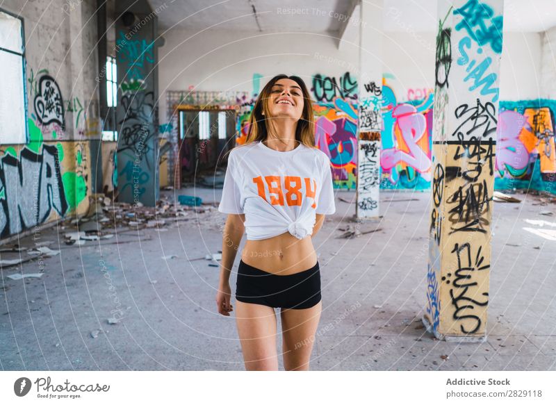 Smiling woman in abandoned room with graffiti Woman Cheerful Posture Looking into the camera Happy Youth (Young adults) grungy Graffiti Multicoloured Room