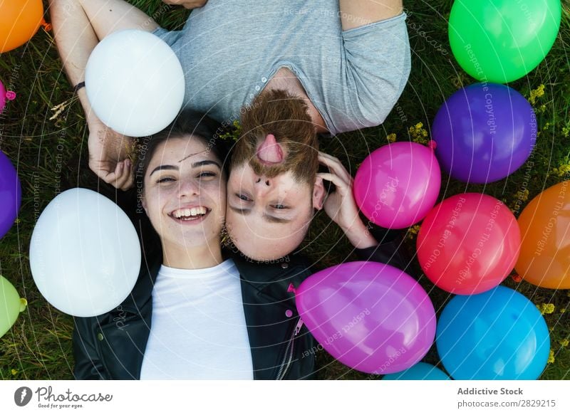 Couple having fun in balloons Woman Man Together covering face Smiling Love Nature Friendship Human being pretty handsome bearded Posture Freedom Joy Beautiful