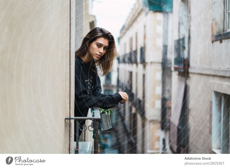 Pretty woman standing at window Woman Home Youth (Young adults) Beautiful Window Handrail hanging out Balcony Posture To enjoy Attractive Hot pretty