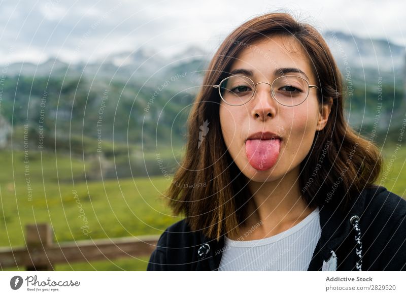 Woman sticking out tongue in mountain meadow Meadow Relaxation Mountain Nature Field Girl Grass Beautiful Youth (Young adults) Green Spring Human being