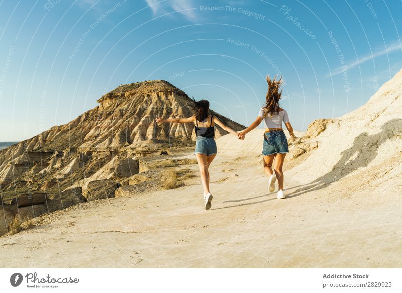 Happy women walking on hill Woman Cliff Excitement Running holding hands Freedom Vacation & Travel Success Top Mountain Youth (Young adults) Nature Rock