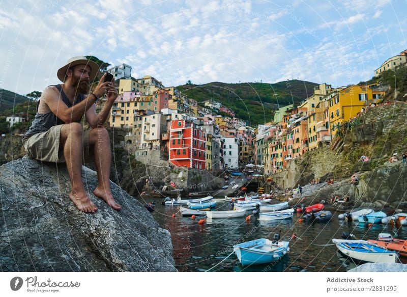 Man with phone on coastal city Rock traveler Skyline PDA Bay Tourist Nature Cliff Posture Watercraft Connection browsing Tourism using Coast Internet