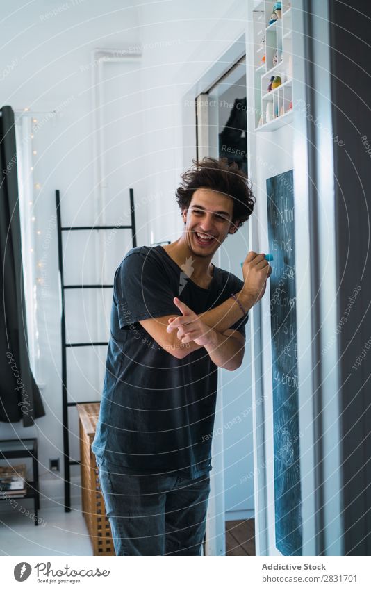 Cheerful man at blackboard at home Man handsome Home Smiling Blackboard Writing Indicate Youth (Young adults) Portrait photograph Lifestyle Human being