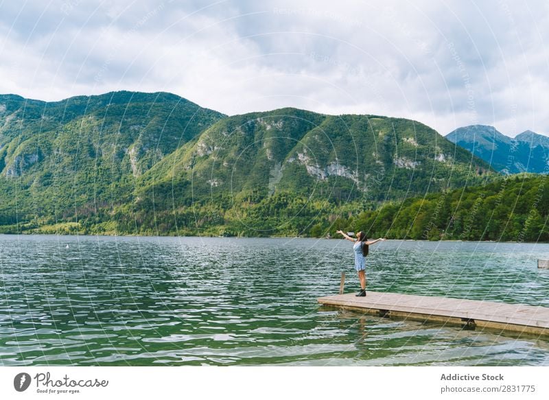 Woman on pier at lake Lake Mountain Jetty hands apart Nature Summer Water Youth (Young adults) Vacation & Travel Lifestyle Human being Beautiful Landscape Girl