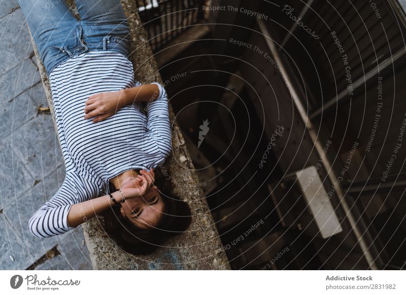 Laughing young girl lying on fence Human being Cheerful Laughter Town Fence Posture human face Playful Joy Brunette Portrait photograph Charming Natural Happy