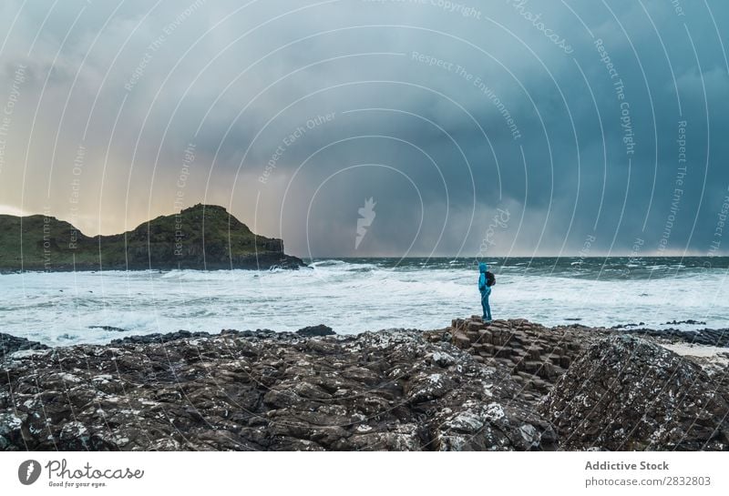 Tourist standing at wavy ocean Coast seaside Rock Ocean Landscape Vacation & Travel Stand Beach Nature Water Natural seascape Stone Beautiful Northern Ireland