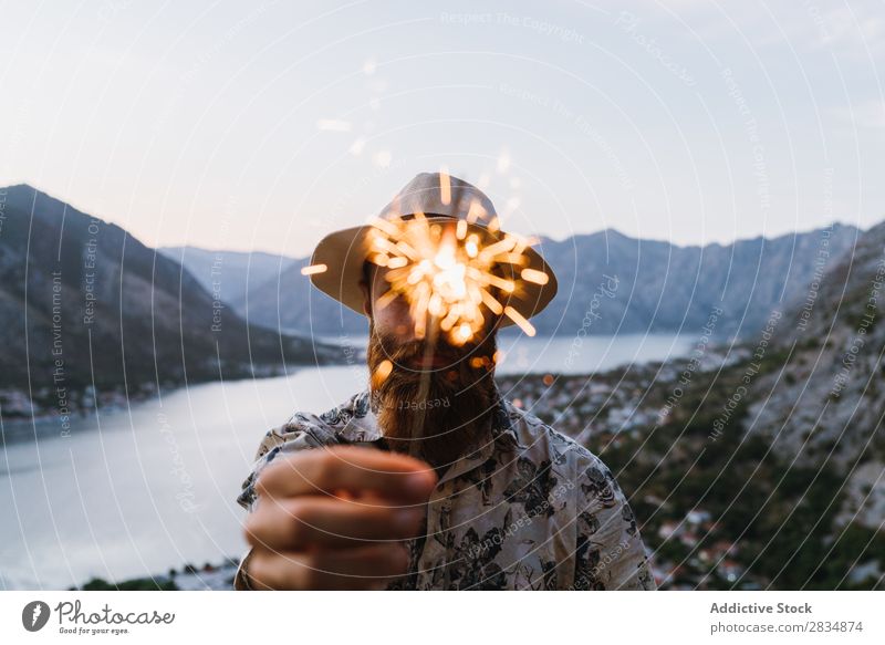 Man with sparkler in mountains Town Mountain River Human being Tourist Sparkler firework Festive Guest bearded Village Vantage point pathway Landscape