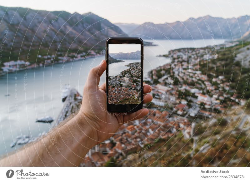 Hand taking shots of mountain town Town Mountain River Human being Tourist PDA Illustration Take Screen Display Village Vantage point pathway Landscape