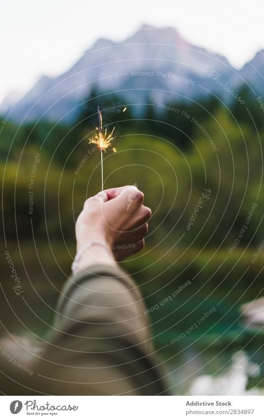 Crop hand holding sparkler on nature Woman Hand Sparkler Nature Mountain Feasts & Celebrations Flame burning firework shine Light Magic Decoration Bright Bengal