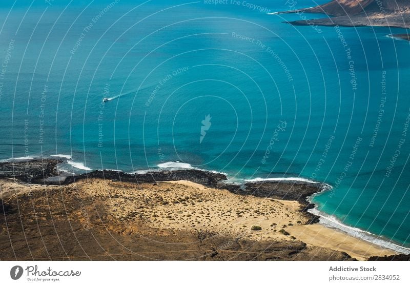 Small boat in blue sea Ocean Island Clouds Vessel Floating Aircraft Nature Landscape Natural Rock Blue Stone Lanzarote Spain Vantage point Vacation & Travel