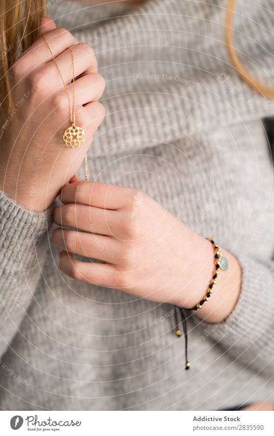 Vertical portrait of young woman touching her necklace. pretty beautiful looking at camera sensual female dreamy thoughtful collar pensive sweater casual face