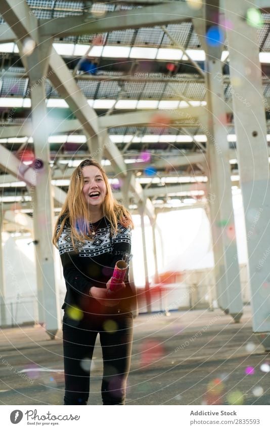 Young woman throwing up the confetti throw up celebrate fun colorful bright pretty standing cheerful happy joyful smiling happiness young beautiful female