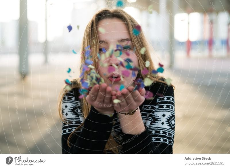 Woman blowing the confetti Blow Confetti Joy Hand Multicoloured Looking into the camera Bright pretty Stand Flying Hair Cheerful Happy Smiling Happiness