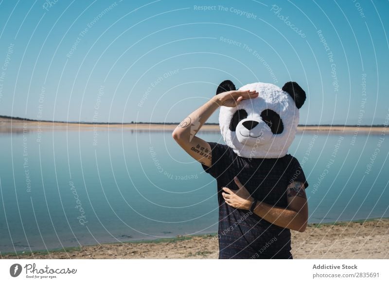 Traveler in creative hat posing on lake Man Discovery Panda Costume Traveling Nature Expedition Hat Tourism gesturing Wanderlust Creativity Wear having fun