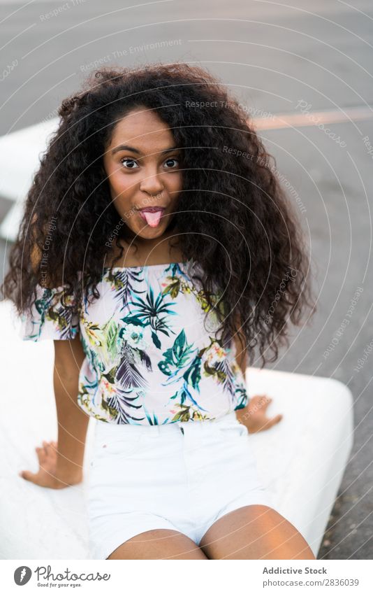 Woman making faces on road pretty Sit Street Asphalt grimacing Youth (Young adults) tongue out Portrait photograph Looking into the camera Black African City