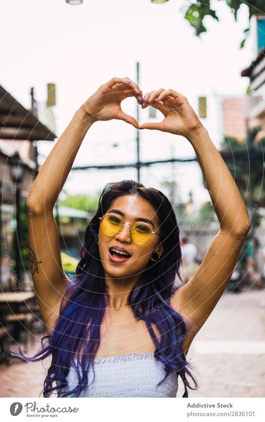 Woman gesturing heart on street pretty Street Youth (Young adults) Beautiful Heart Hands up! shoving Love Symbols and metaphors Portrait photograph Hair Purple